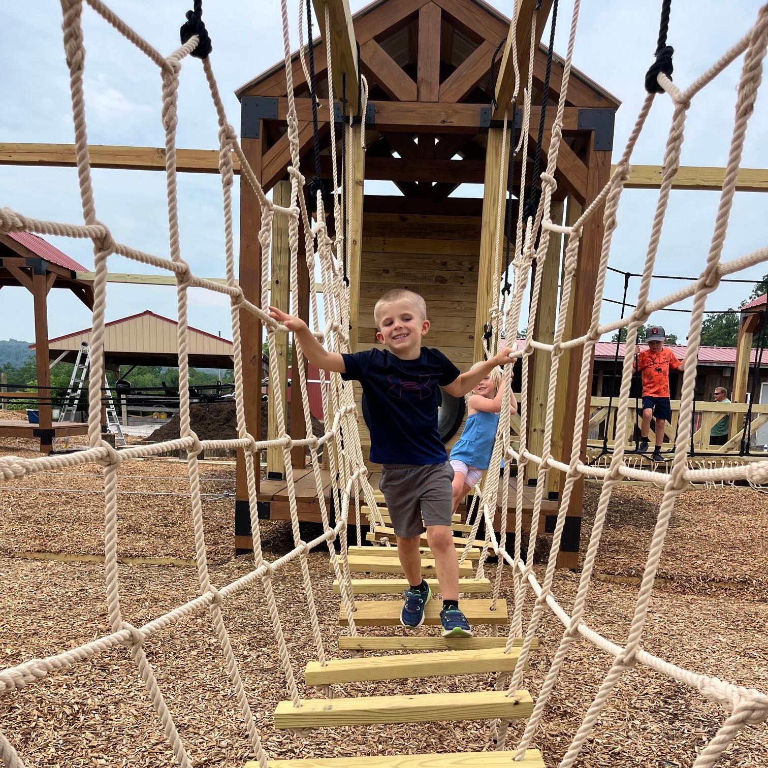 Boy crossing a rope bridge on the playground